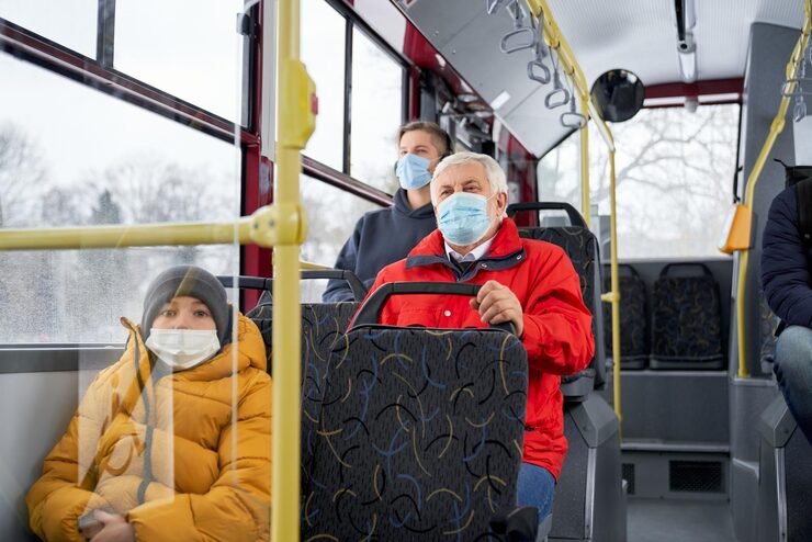 Passengers sitting on bus wearing medical masks protecting from global pandemic