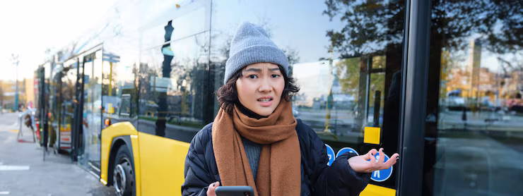Portrait of confused young woman looking at her smartphone app with shocked and disappointed face